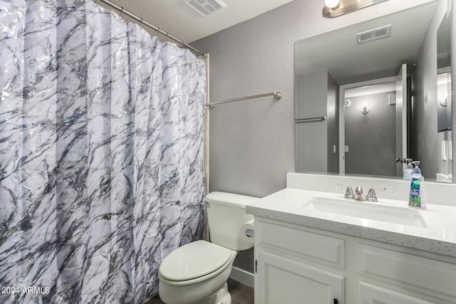 full bathroom with visible vents, toilet, vanity, and a textured wall