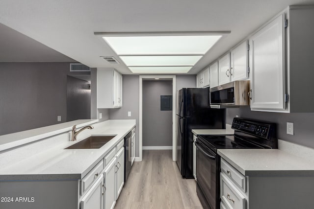 kitchen featuring light wood-type flooring, black appliances, white cabinetry, and sink