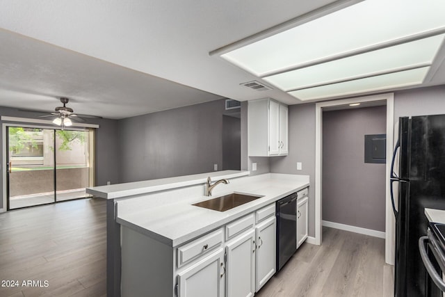 kitchen featuring dishwashing machine, light wood-style flooring, freestanding refrigerator, a sink, and light countertops