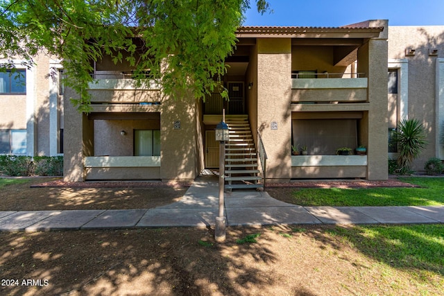 exterior space featuring stairway, stucco siding, and a balcony