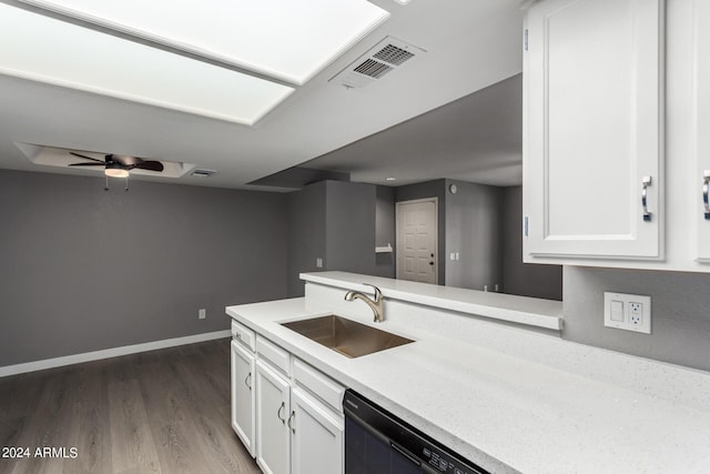 kitchen featuring dishwashing machine, white cabinets, visible vents, and a sink