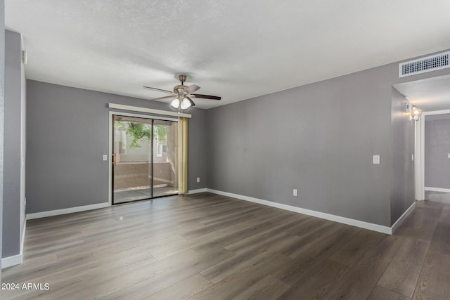 unfurnished room with visible vents, wood finished floors, baseboards, and ceiling fan