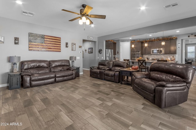 living room featuring ceiling fan and wood-type flooring