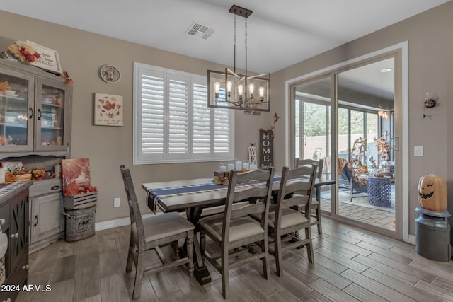 dining area featuring light wood-type flooring, a chandelier, and a healthy amount of sunlight