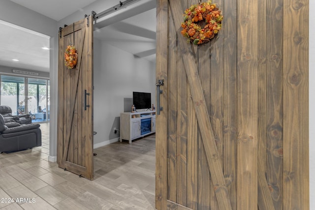 hall featuring a barn door and light hardwood / wood-style flooring