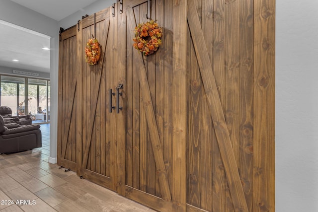 room details featuring a barn door and hardwood / wood-style floors