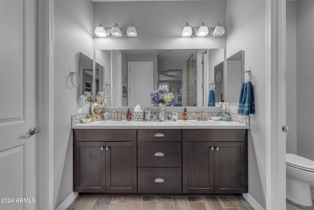 bathroom featuring toilet, vanity, and hardwood / wood-style floors