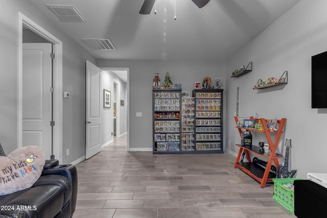 living area featuring light hardwood / wood-style floors and ceiling fan