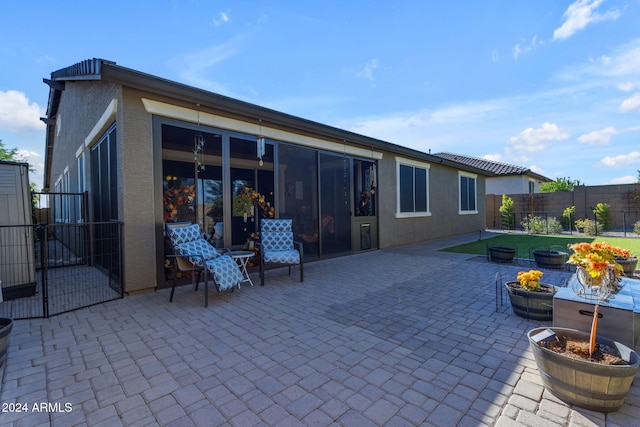 rear view of house with a patio and a sunroom