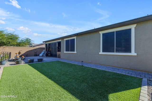 back of property with a patio and a yard