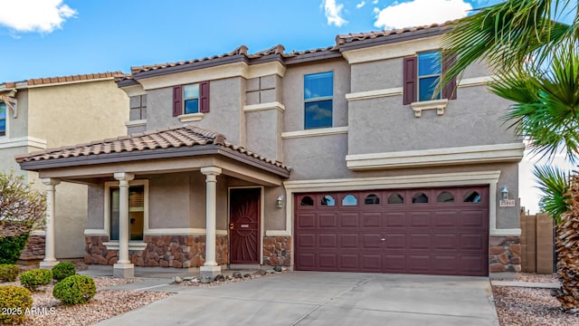 mediterranean / spanish home with an attached garage, stone siding, driveway, and stucco siding