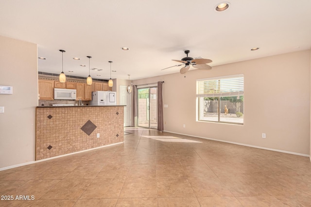 unfurnished living room featuring a ceiling fan, a sink, recessed lighting, light tile patterned floors, and baseboards