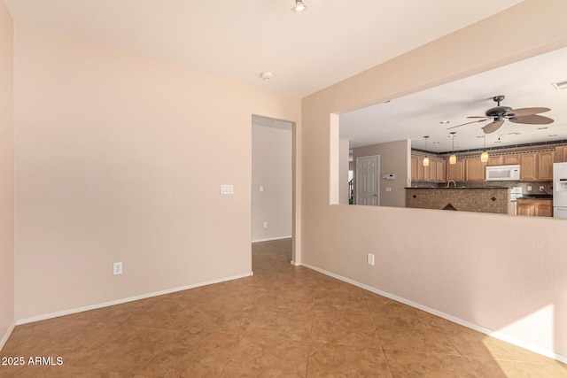 unfurnished room with visible vents, baseboards, and ceiling fan