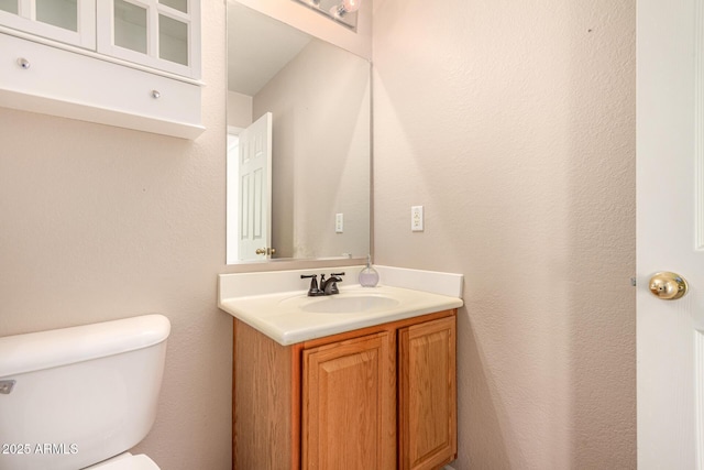 half bath featuring toilet and vanity