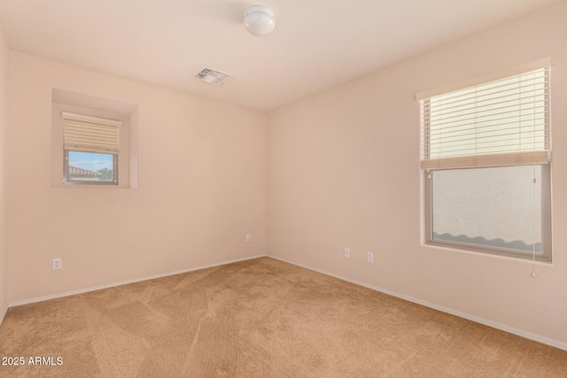 carpeted spare room with visible vents and baseboards