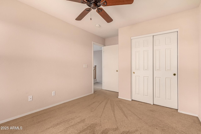 unfurnished bedroom with a closet, carpet flooring, ceiling fan, and baseboards