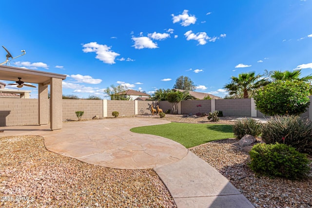 view of yard with a fenced backyard, a patio, and ceiling fan