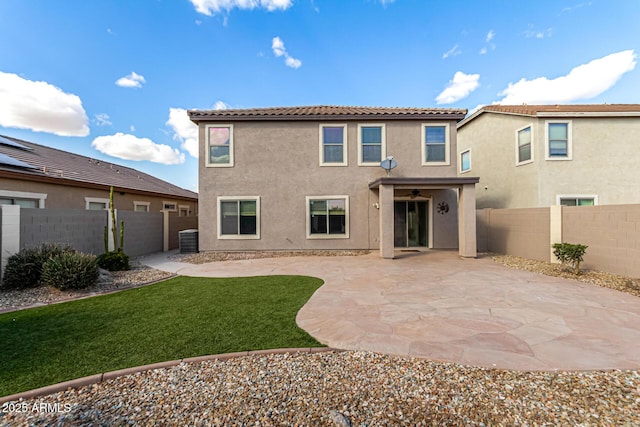 rear view of house with a patio area, stucco siding, and a fenced backyard