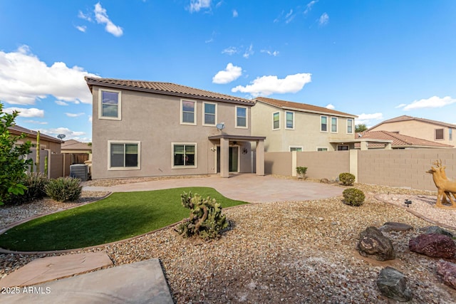 back of house with a patio, a fenced backyard, stucco siding, central air condition unit, and a lawn