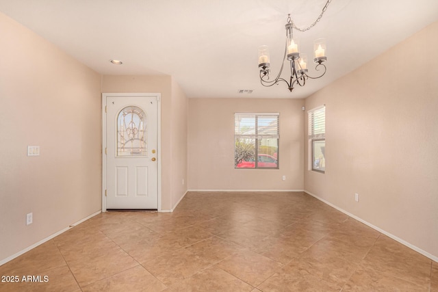 foyer with an inviting chandelier, light tile patterned floors, baseboards, and visible vents