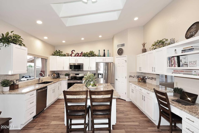 kitchen with dark hardwood / wood-style flooring, a center island, sink, and stainless steel appliances