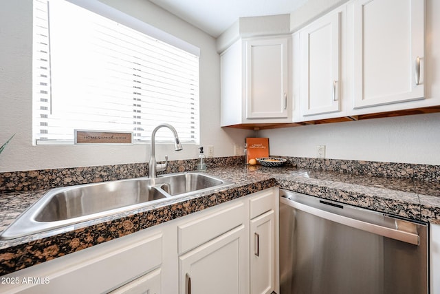 kitchen featuring dark countertops, white cabinets, a sink, and stainless steel dishwasher