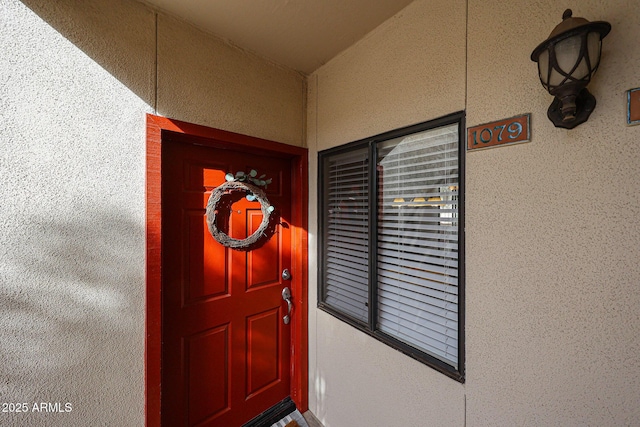 entrance to property with stucco siding