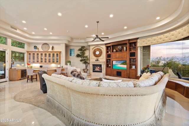 6621 N Arizona Biltmore Cir, Phoenix, AZ 85016 - living area with a tray ceiling, recessed lighting, a fireplace, a ceiling fan, and wine cooler
