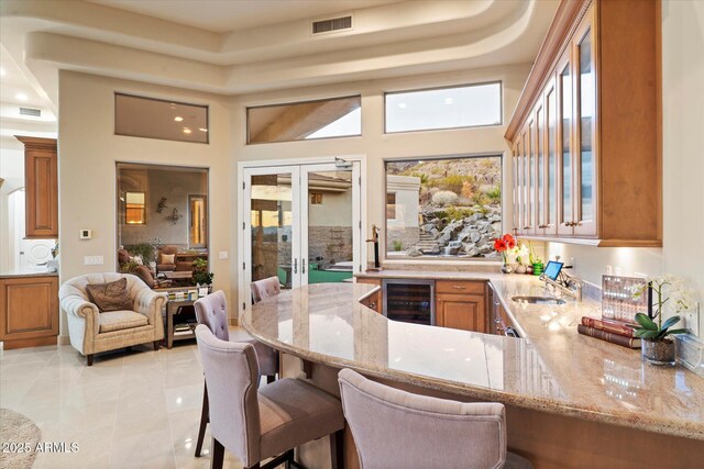 6621 N Arizona Biltmore Cir, Phoenix, AZ 85016 - bar area featuring beverage cooler, french doors, a sink, a tray ceiling, and a high ceiling