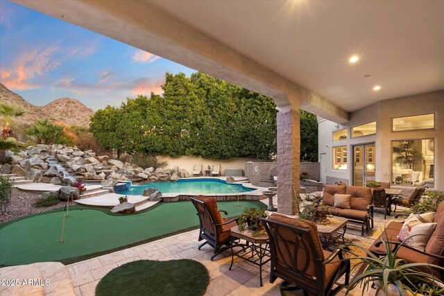 6621 N Arizona Biltmore Cir, Phoenix, AZ 85016 - view of patio / terrace with an area to practice putting, an outdoor pool, an outdoor living space, and a mountain view