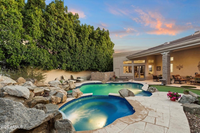 6621 N Arizona Biltmore Cir, Phoenix, AZ 85016 - pool at dusk featuring french doors, a patio area, and a pool with connected hot tub