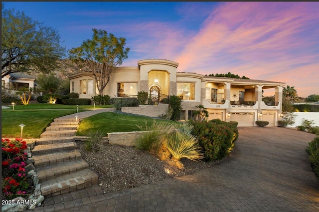 6621 N Arizona Biltmore Cir, Phoenix, AZ 85016 - mediterranean / spanish house featuring an attached garage, stucco siding, driveway, and a lawn