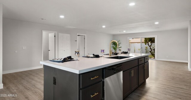 kitchen with a sink, light wood-style floors, light countertops, dishwasher, and recessed lighting