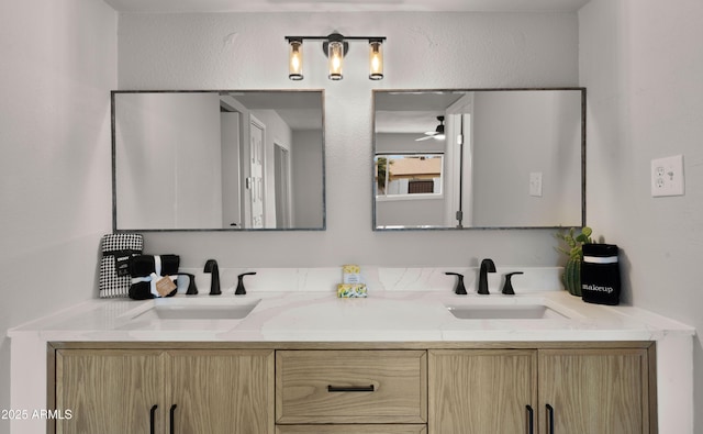 bathroom with double vanity, a sink, and a ceiling fan
