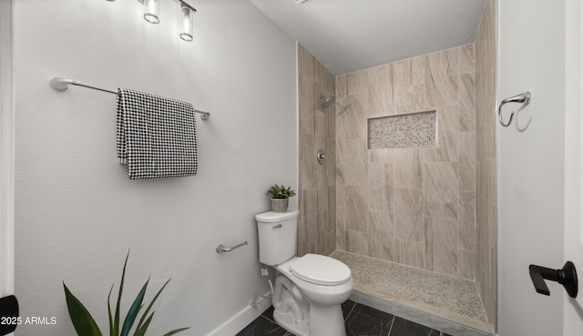 full bathroom with baseboards, a tile shower, and toilet