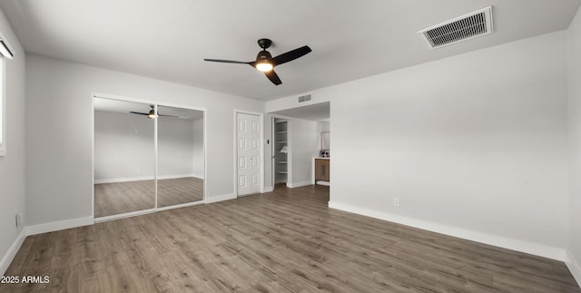unfurnished bedroom with baseboards, visible vents, and wood finished floors