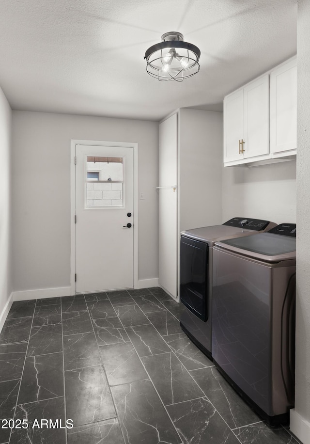 laundry area with baseboards, independent washer and dryer, cabinet space, and marble finish floor
