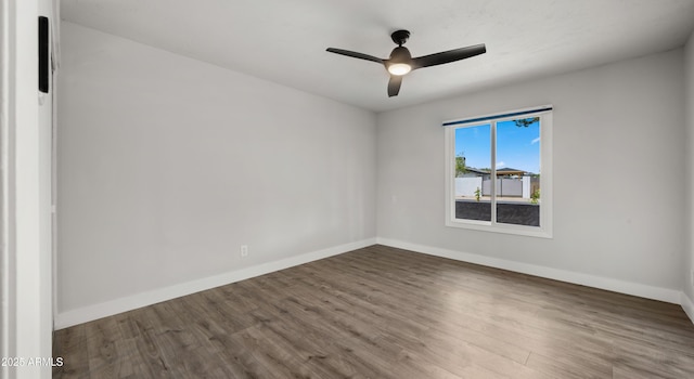 unfurnished room with baseboards, ceiling fan, and wood finished floors