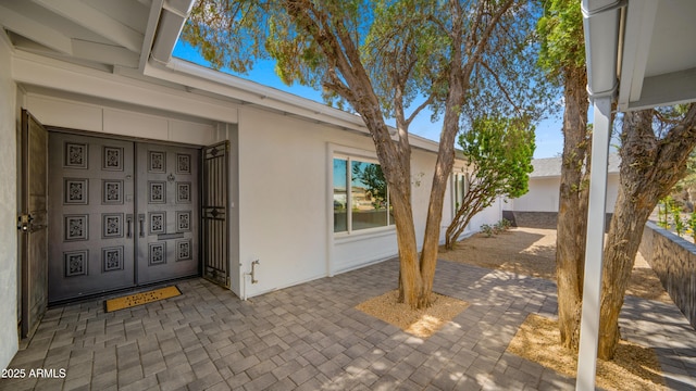 view of exterior entry with stucco siding