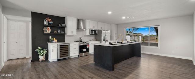 kitchen with a sink, light countertops, wall chimney exhaust hood, stainless steel appliances, and wine cooler