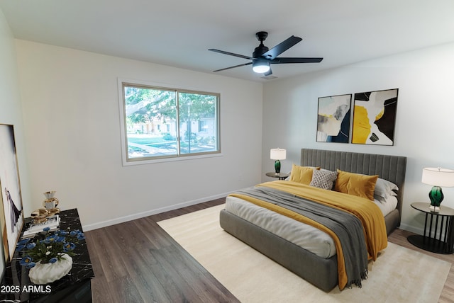 bedroom featuring baseboards, ceiling fan, and wood finished floors