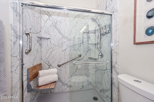 bathroom featuring toilet and an enclosed shower