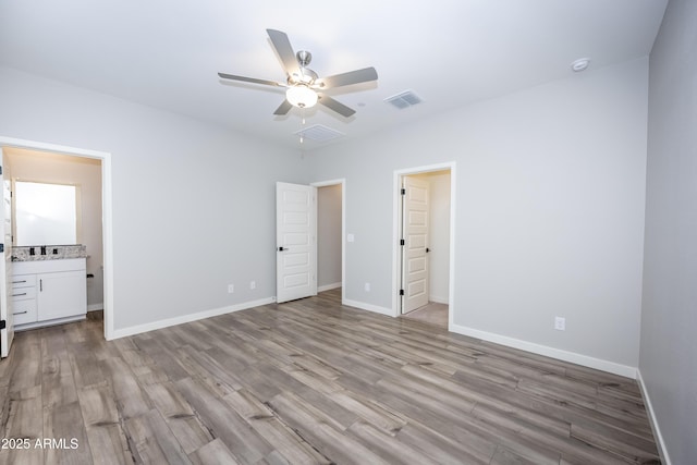 unfurnished bedroom featuring ceiling fan, connected bathroom, and light hardwood / wood-style floors