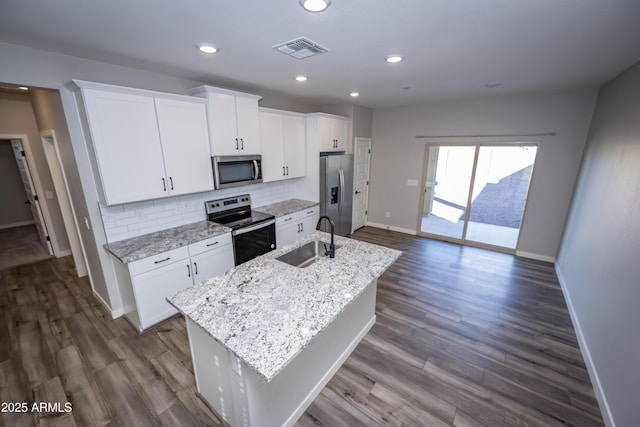 kitchen featuring sink, appliances with stainless steel finishes, a kitchen island with sink, tasteful backsplash, and white cabinets