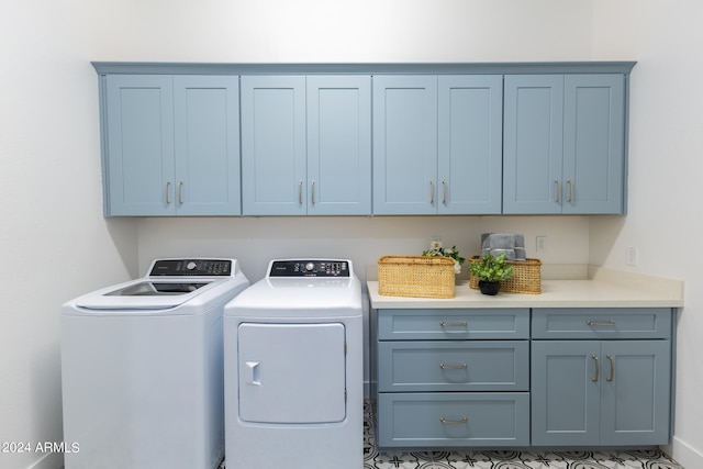 washroom featuring cabinets, separate washer and dryer, and light tile floors