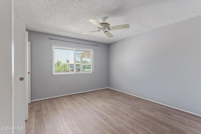 10236 N 105th Dr, Sun City, AZ 85351 - empty room featuring wood finished floors, a textured ceiling, a ceiling fan, and baseboards