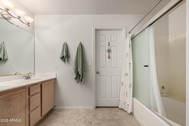 bathroom featuring baseboards, double vanity, tile patterned floors, shower / bath combination with curtain, and a sink