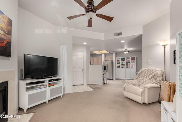 living room with a ceiling fan, visible vents, recessed lighting, light carpet, and a tiled fireplace