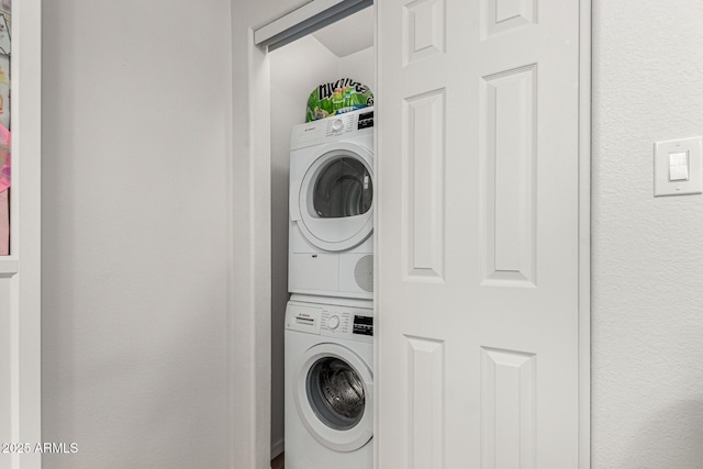 washroom featuring laundry area and stacked washer / dryer