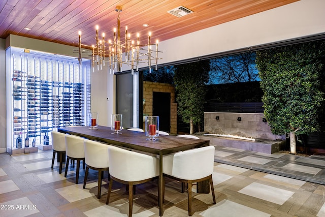 dining area with a chandelier, visible vents, and wood ceiling